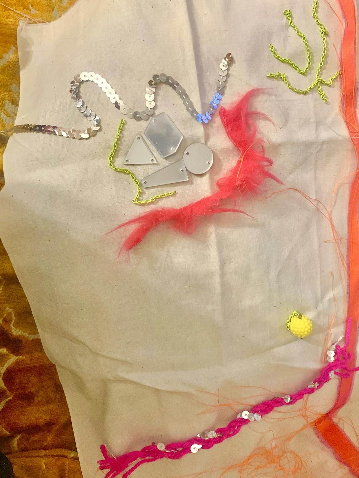 Bright and reflective materials are placed on top of a piece of fabric.